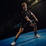 Athlete wearing the Combi Deal Black padel clothing set, in an action shot demonstrating the performance, flexibility, and comfort of the gear on the court.