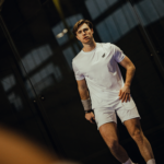 Athlete in the Combi Deal White padel clothing set, moving confidently on the court, showcasing the gear's comfort, style, and performance features.