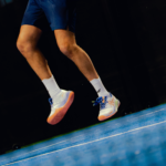 Athlete wearing white Performance Socks, demonstrating flexibility and comfort during a padel match. Designed for optimal performance and support.