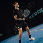 Athlete wearing the Performance Shirt Black, showcasing its comfort and flexibility while playing padel, with a focus on style and performance.