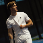 Atleet draagt het Performance Shirt White, dat comfort en flexibiliteit toont tijdens een padelwedstrijd, met nadruk op het strakke ontwerp en ademende stof.