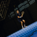 Athlete wearing the Performance Short Navy, captured mid-action on the padel court, demonstrating the shorts' flexibility, fit, and performance during intense movement.