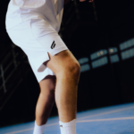 Athlete wearing the Performance Short White, captured mid-action on the padel court, highlighting the shorts’ fit, comfort, and flexibility for peak performance.