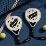 Two Gabriq Elvone WMNS Pro padel rackets on a padel court with balls and net