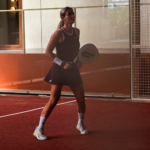 Woman wearing Gabriq brown performance set volleying at the net on a padel court